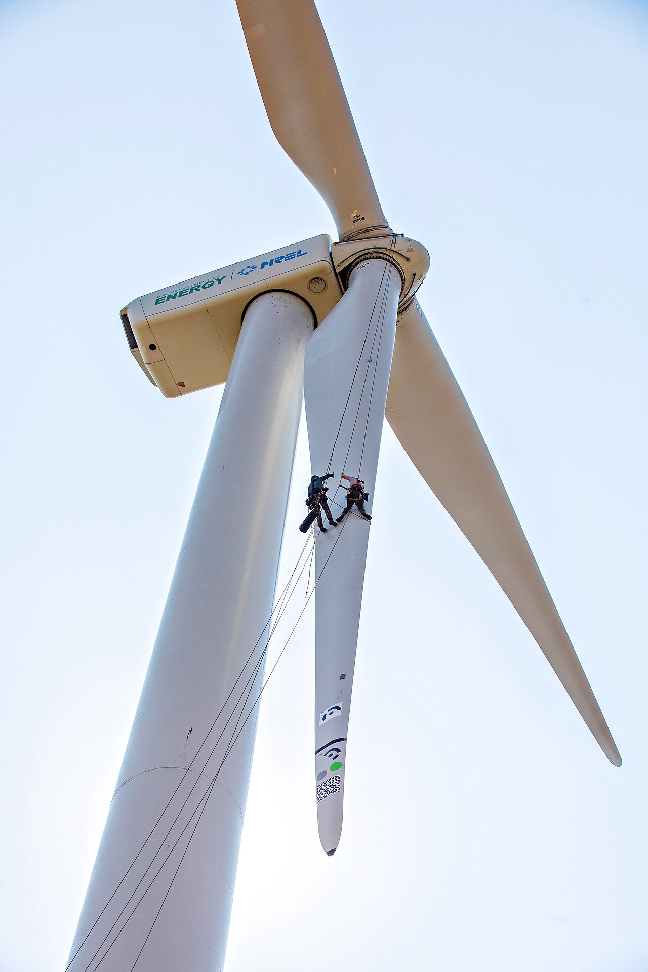 Technician inspecting a wind turbine blade during renewable-energy maintenance